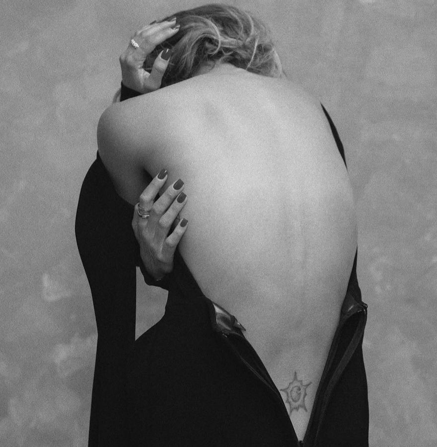 Black and white: hand on the bare back, short dark nails